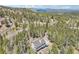 Aerial view of a mountainside house surrounded by lush forest and scenic mountain views at 10469 Christopher Dr, Conifer, CO 80433