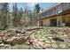 Scenic backyard featuring stone landscaping, mature trees, and a spacious deck, perfect for outdoor relaxation at 10469 Christopher Dr, Conifer, CO 80433