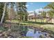 Back of the house showing the pond reflecting nature, large deck, and wooded surroundings at 10469 Christopher Dr, Conifer, CO 80433