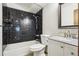 Bathroom with black tile surround, shower-tub combination, and modern fixtures at 10469 Christopher Dr, Conifer, CO 80433