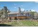 Exterior of home featuring a large deck, beautifully landscaped yard, and a charming backyard at 10469 Christopher Dr, Conifer, CO 80433