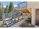 Exterior featuring a large deck with stairs, a 'Welcome' sign, and a landscaped yard at 10469 Christopher Dr, Conifer, CO 80433