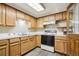 Kitchen with white appliances, wooden cabinets, and light countertops at 10469 Christopher Dr, Conifer, CO 80433