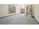 Spacious living room with a large window, carpeting, and a door leading to the outside at 10469 Christopher Dr, Conifer, CO 80433