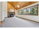Spacious living room with wood-paneled ceiling, stone fireplace, and scenic views at 10469 Christopher Dr, Conifer, CO 80433