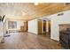 Spacious living room with wood-paneled ceiling, wood burning stove, and luxury vinyl plank flooring at 10469 Christopher Dr, Conifer, CO 80433