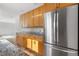 Spacious kitchen featuring wood cabinets, granite countertops, and a modern stainless steel refrigerator at 1243 N Washington St # 308, Denver, CO 80203