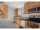 Well-lit kitchen featuring wood cabinets, granite countertops, and stainless steel appliances at 1243 N Washington St # 308, Denver, CO 80203