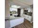 Well-lit kitchen features white cabinets, an island with a cooktop, and stylish countertops at 2746 S Kenton Ct, Aurora, CO 80014