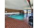 Bright indoor swimming pool with brick walls, tile flooring, lounge chairs, and large windows at 2746 S Kenton Ct, Aurora, CO 80014