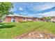 Spacious backyard with a well-maintained lawn, patio, and play structure at 1304 S Harlan St, Lakewood, CO 80232