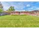 Expansive backyard featuring a lush lawn, a patio area, and serene outdoor space for relaxation at 1304 S Harlan St, Lakewood, CO 80232