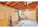 Unfinished basement featuring washer, dryer, storage, and exposed ceiling at 1304 S Harlan St, Lakewood, CO 80232