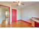 Bedroom with hardwood floors, a desk, and a red door at 1304 S Harlan St, Lakewood, CO 80232