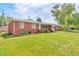 Well-maintained brick home with a lush green lawn and a charming front porch at 1304 S Harlan St, Lakewood, CO 80232