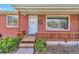 Welcoming front porch showcasing a decorative bench, brick facade, and pleasant curb appeal at 1304 S Harlan St, Lakewood, CO 80232