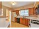 Well-lit kitchen with a practical layout, wooden cabinets, and views into the adjacent dining area at 1304 S Harlan St, Lakewood, CO 80232
