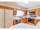 Functional kitchen with wood cabinetry, white countertops, and essential appliances for cooking at 1304 S Harlan St, Lakewood, CO 80232