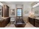 A copper standalone tub is featured in a bathroom with dark wood cabinets and granite countertops at 9617 S Shadow Hill Cir, Lone Tree, CO 80124