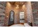 Grand foyer showcasing brick walls, arched doorway, decorative chandelier, and a glimpse of the dining area at 9617 S Shadow Hill Cir, Lone Tree, CO 80124