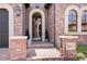 Elegant front entrance with brick facade, arched gate, decorative lanterns, and visible house number at 9617 S Shadow Hill Cir, Lone Tree, CO 80124