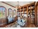 Spacious office with custom wood built-ins, unique light fixture, and multiple windows at 9617 S Shadow Hill Cir, Lone Tree, CO 80124