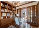 Spacious office with custom wood built-ins and glass doors that lead to an outdoor sitting area at 9617 S Shadow Hill Cir, Lone Tree, CO 80124