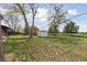Large grassy backyard featuring mature trees and a storage shed at 2840 Cottonwood Dr, Denver, CO 80221