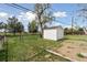 View of backyard with a white shed and garden plots at 2840 Cottonwood Dr, Denver, CO 80221
