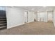 Finished basement with neutral carpet, white walls, and a laundry area at 2840 Cottonwood Dr, Denver, CO 80221