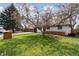 Beautifully landscaped front yard featuring mature trees and a well-maintained lawn at 2840 Cottonwood Dr, Denver, CO 80221
