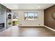 Bright living room with modern fireplace, hardwood floors, and a large window showcasing the front yard at 2840 Cottonwood Dr, Denver, CO 80221