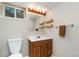 Simple bathroom featuring neutral walls, wood shelving, and oak vanity at 2954 E 101St Ave, Thornton, CO 80229