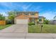 Traditional two-story home with stone accents, a well-manicured lawn, and a large driveway at 2954 E 101St Ave, Thornton, CO 80229
