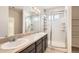 Double vanity bathroom featuring large mirror, vanity lighting and glass enclosed shower at 4672 Basalt Ridge Cir, Castle Rock, CO 80108