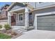 Welcoming front porch with stone pillars, a gray exterior, and a convenient two-car garage at 4672 Basalt Ridge Cir, Castle Rock, CO 80108
