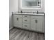 Modern bathroom featuring a double vanity with sleek countertops and a well-lit mirror at 1345 Holly St, Denver, CO 80220