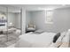 Cozy bedroom showcasing soft, neutral tones, a comfortable armchair, and ample natural light at 1345 Holly St, Denver, CO 80220