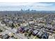 Aerial shot showcasing a neighborhood with lush trees and the city skyline in the distance at 3311 N York St, Denver, CO 80205