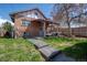 Backyard of a brick home showcasing a covered patio with lounge furniture and a well-maintained lawn at 3311 N York St, Denver, CO 80205