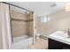 Finished bathroom featuring tiled shower over tub, toilet and single vanity at 3311 N York St, Denver, CO 80205