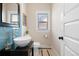 Charming powder room featuring blue tile accents, vessel sink, and stylish mirror at 3311 N York St, Denver, CO 80205