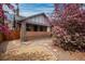 Inviting front yard of a brick home, featuring a cozy porch and a beautiful blooming tree at 3311 N York St, Denver, CO 80205