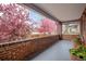 Charming covered porch with brick railing and a view of flowering trees at 3311 N York St, Denver, CO 80205