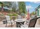 Outdoor seating area with a fire pit, surrounded by a lush green yard with mature trees at 1474 S Uinta Ct, Denver, CO 80231