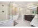 Bright bathroom featuring a soaking tub, glass-enclosed shower, and dark wood vanity at 1474 S Uinta Ct, Denver, CO 80231