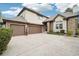 Stunning home exterior showcasing a three-car garage and stone accents at 1474 S Uinta Ct, Denver, CO 80231