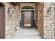 Inviting front entry with stone surround and decorative sconces at 1474 S Uinta Ct, Denver, CO 80231