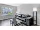 Relaxing living area featuring a plush black sofa, modern coffee table, and ample natural light from the nearby window at 8905 Field St # 91, Westminster, CO 80021