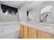 Bathroom featuring a double sink vanity and soaking tub beneath a bright window and stylish curtain at 1479 Nemrick Pl, Castle Rock, CO 80109
